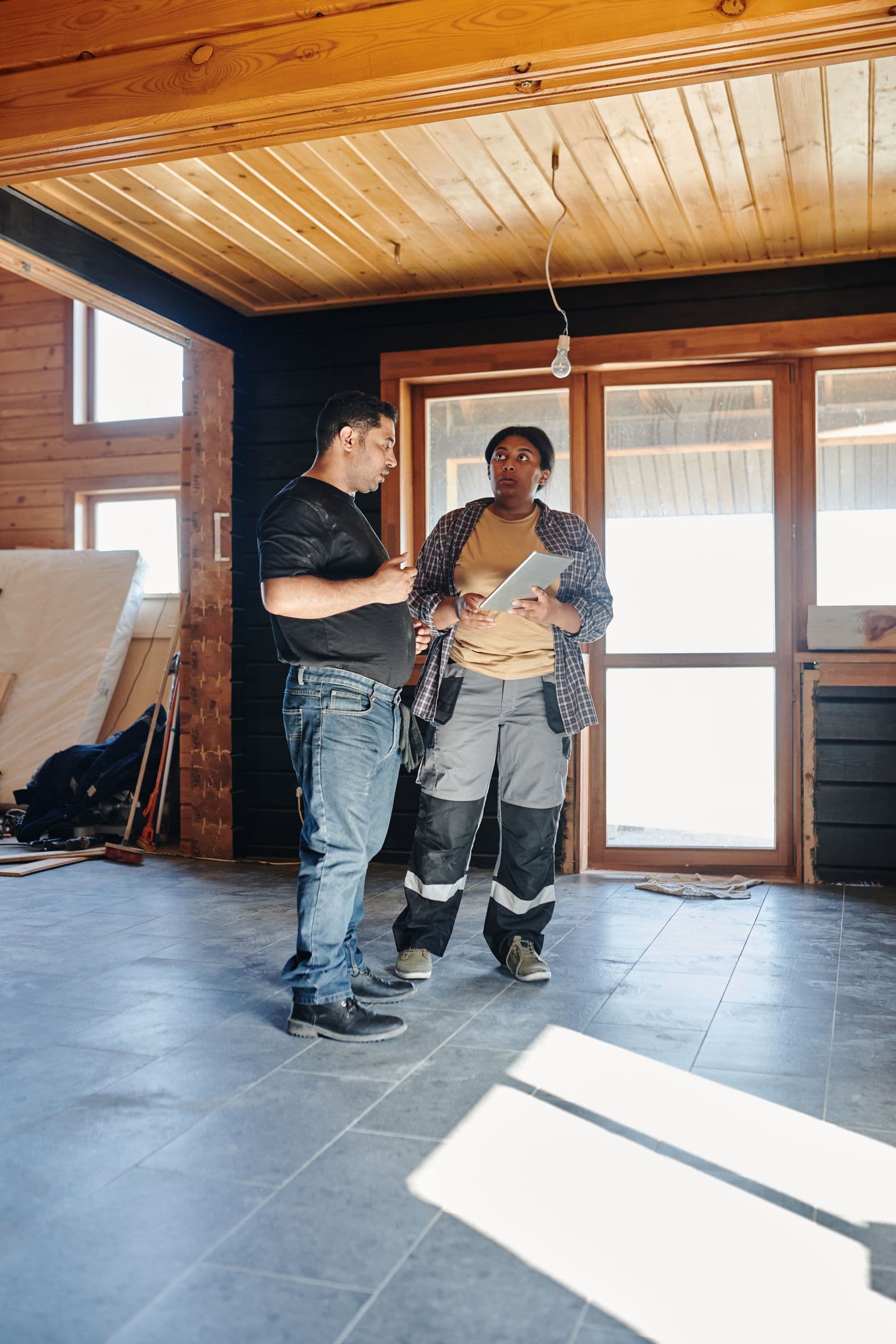 Artisans étudiant les plans d’un chantier avec une tablette